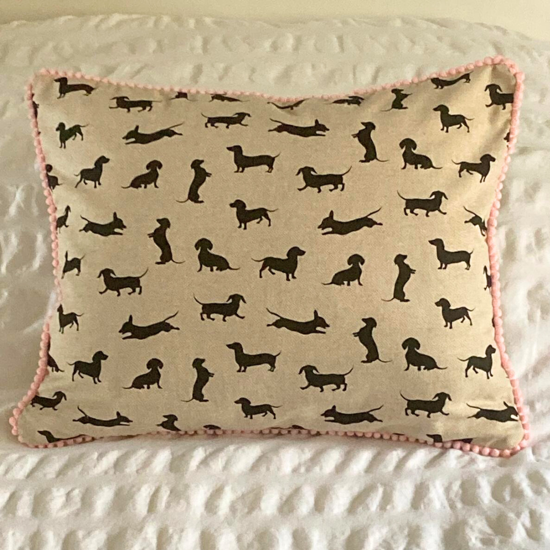 pink trim black dachshund cushion on bed