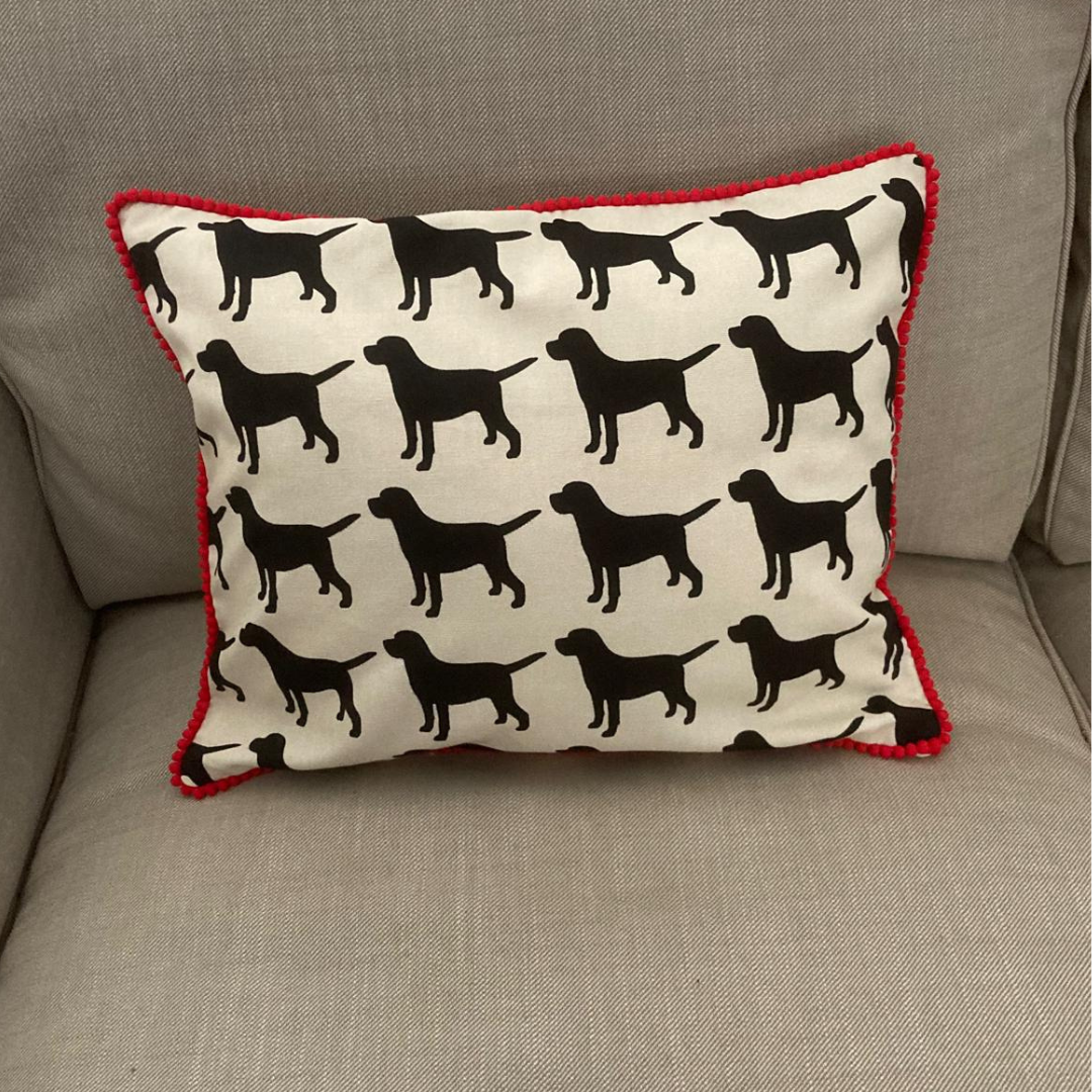 black labrador cushion in red trim on sofa