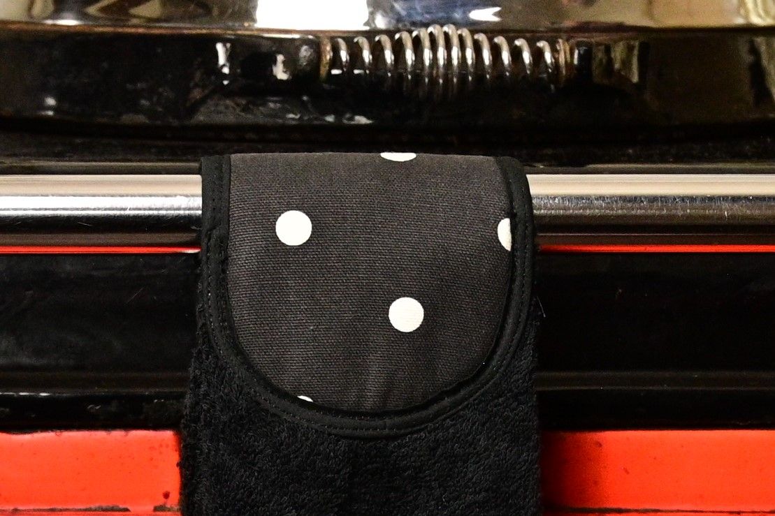 close up of black spots hang up towel on red aga rail