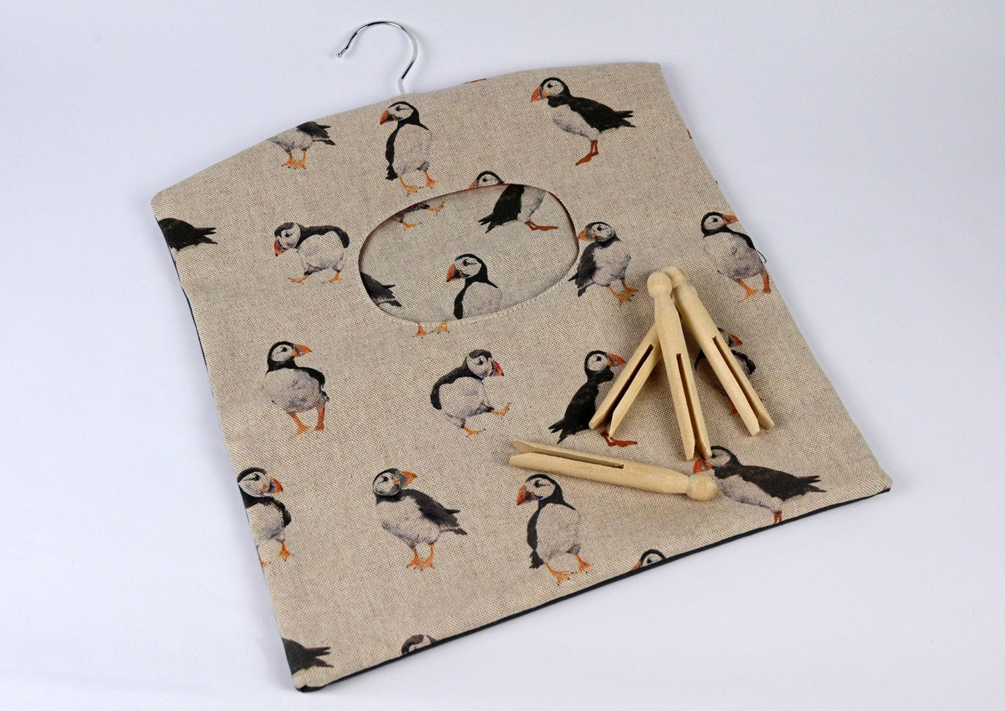 puffins peg bag with pegs on top on white background