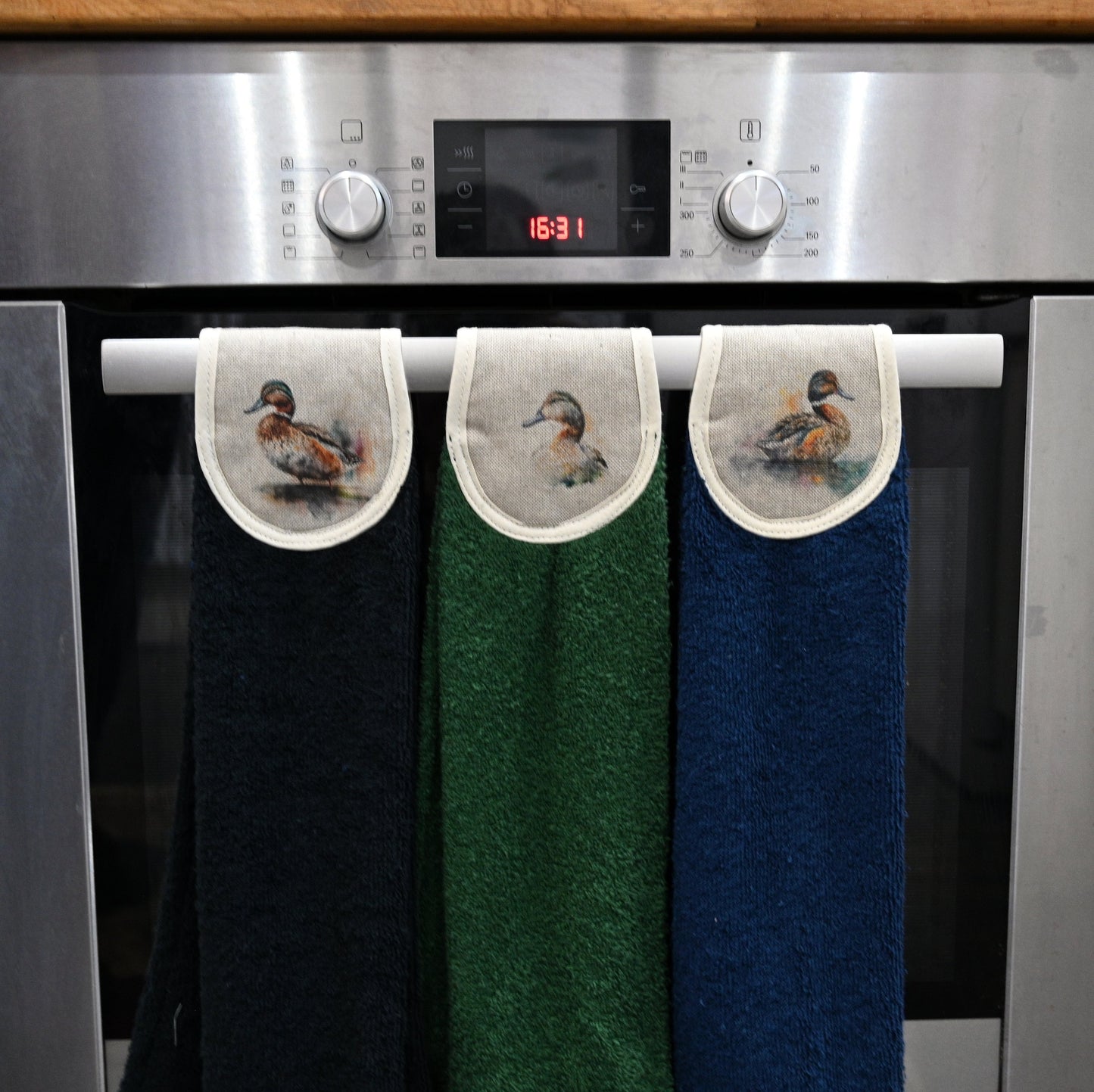 black, green and navy ducks hang ups on kitchen rail