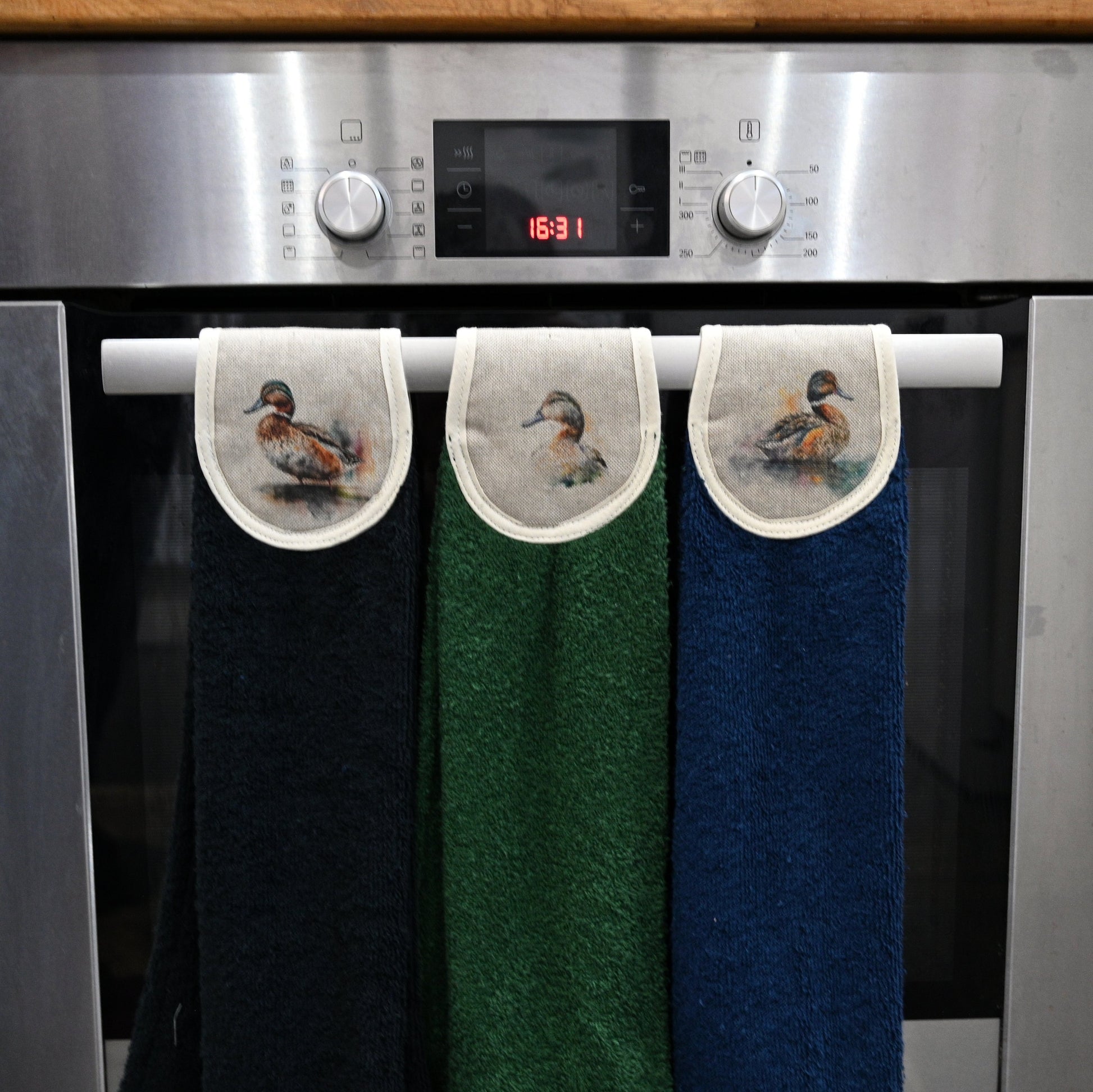 black, green and navy ducks hang ups on kitchen rail
