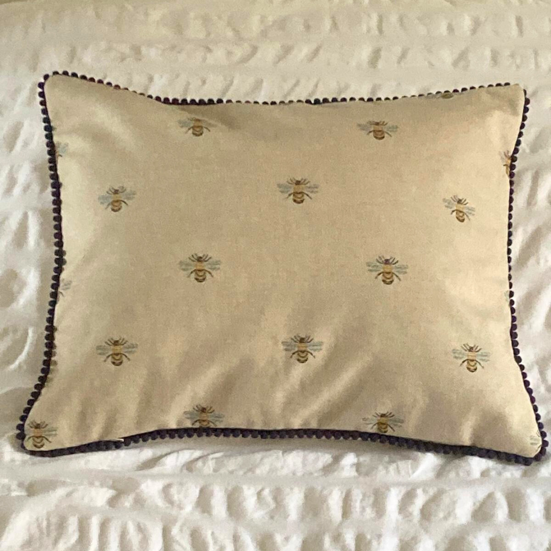 bees cushion on bed with navy trim