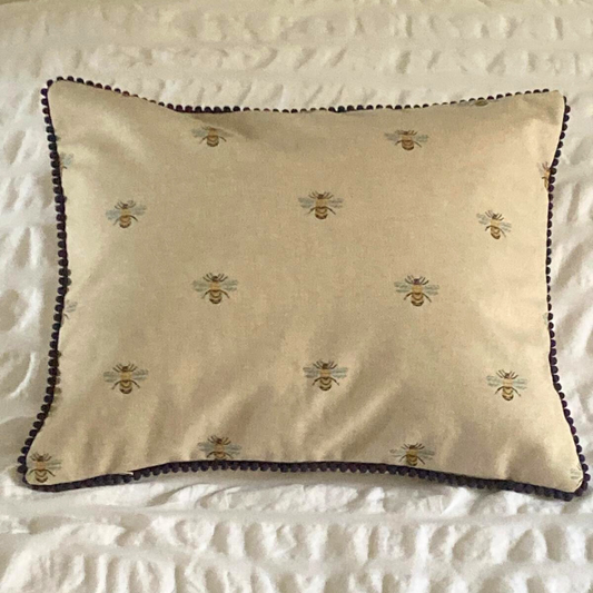 bees cushion on bed with navy trim