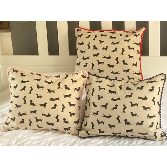 navy, red and pink trim black dachshund cushions on bed