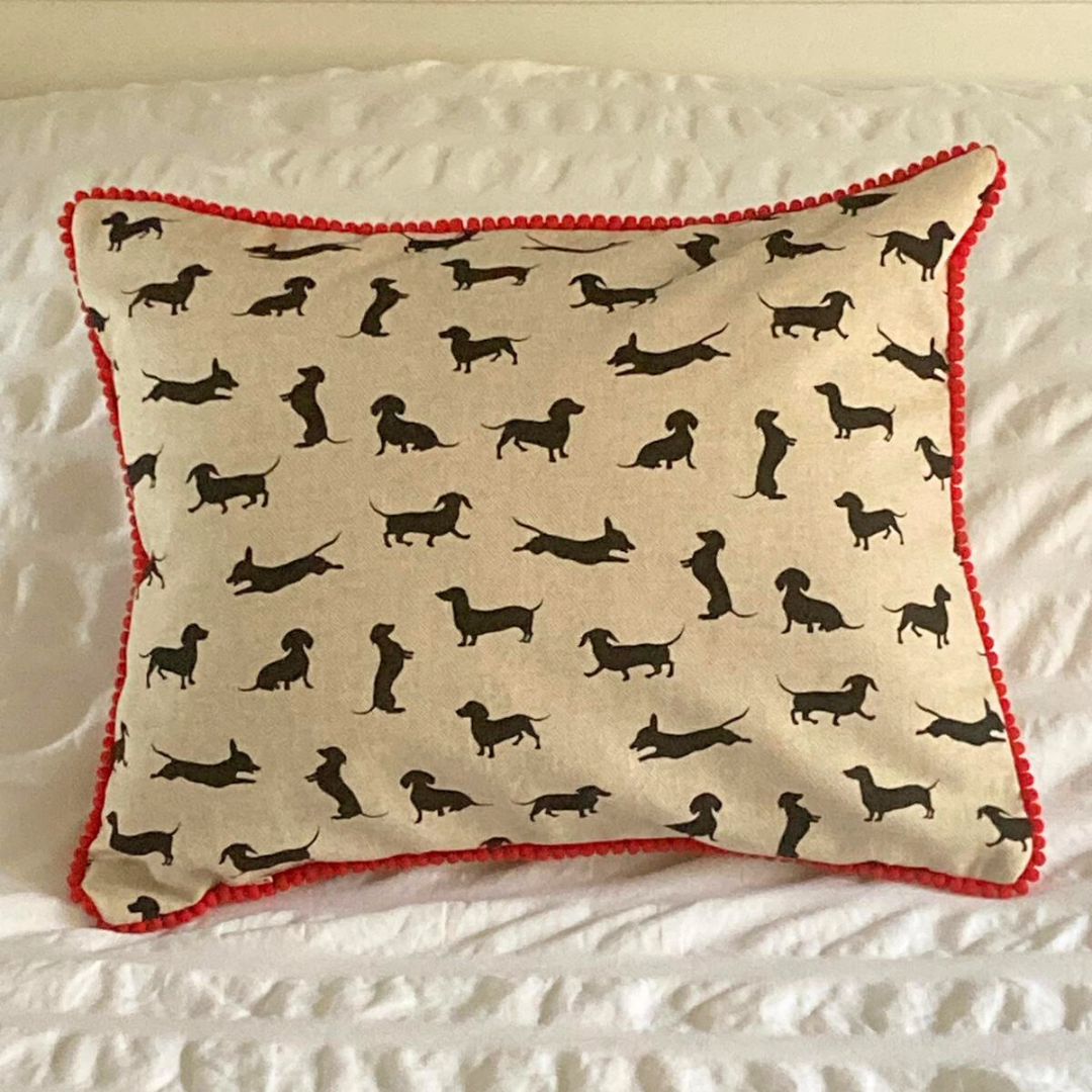 red trim black dachshund cushion on bed