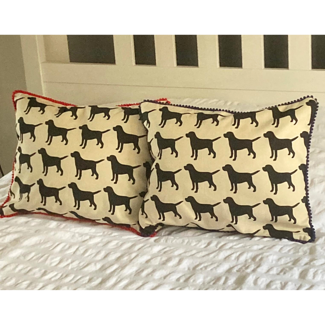 black labrador cushion in red and navy trim on bed