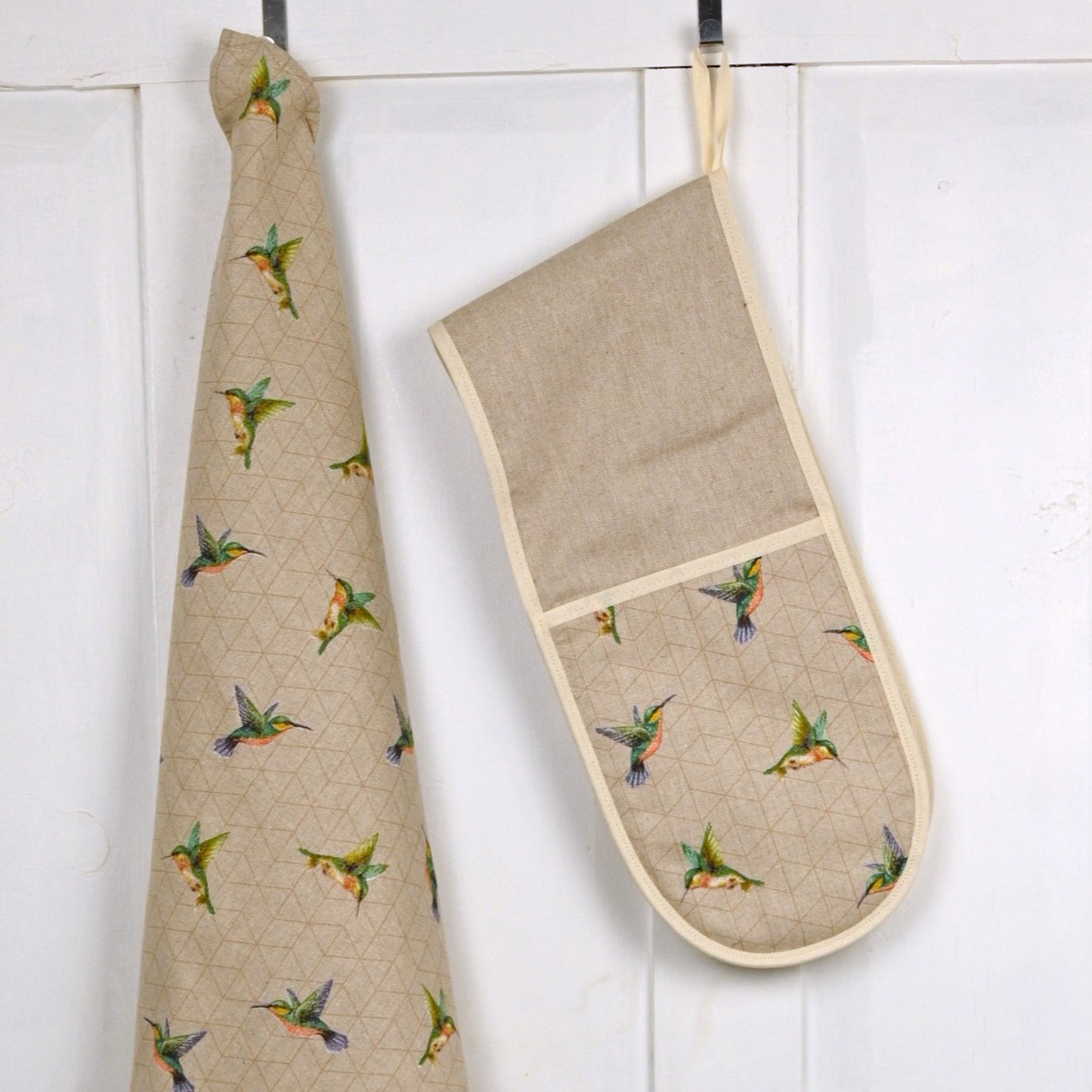 lifestyle hung up humming bird oven gloves next to tea towel