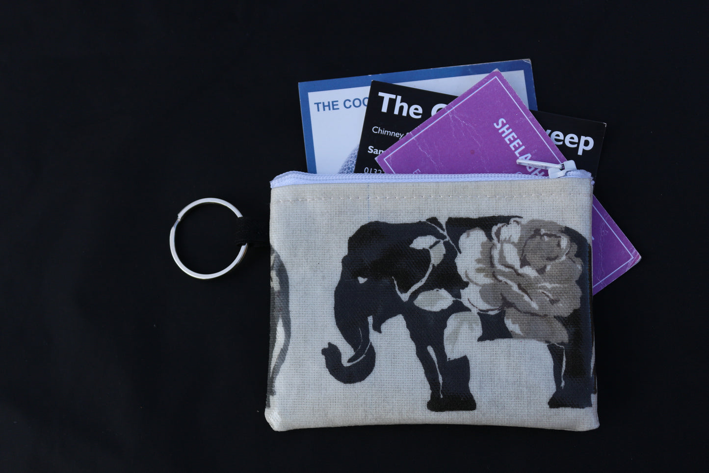 grey elephant purse with business cards poking out