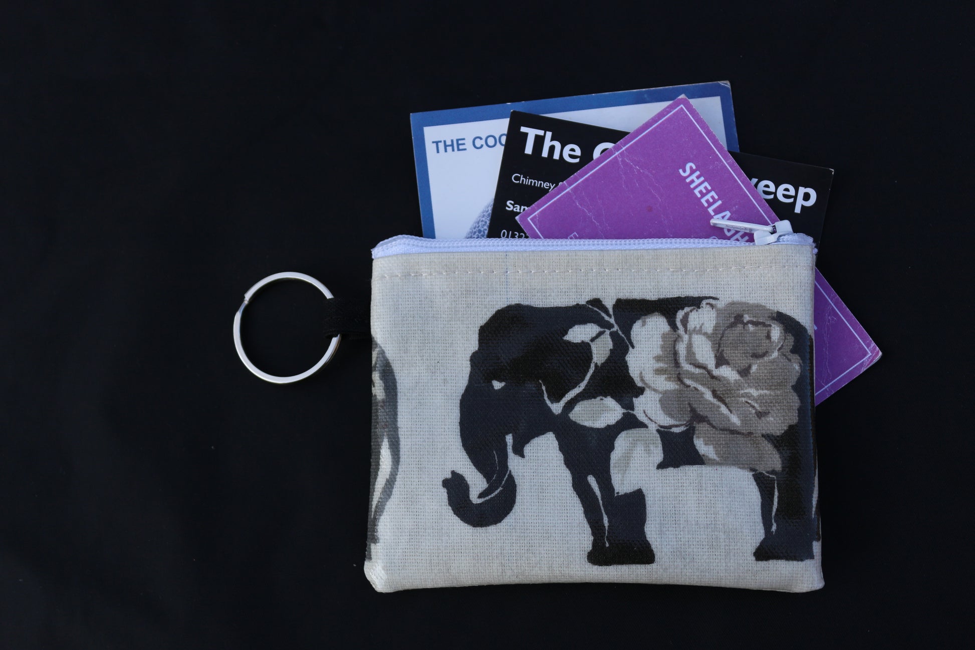 grey elephant purse with business cards poking out