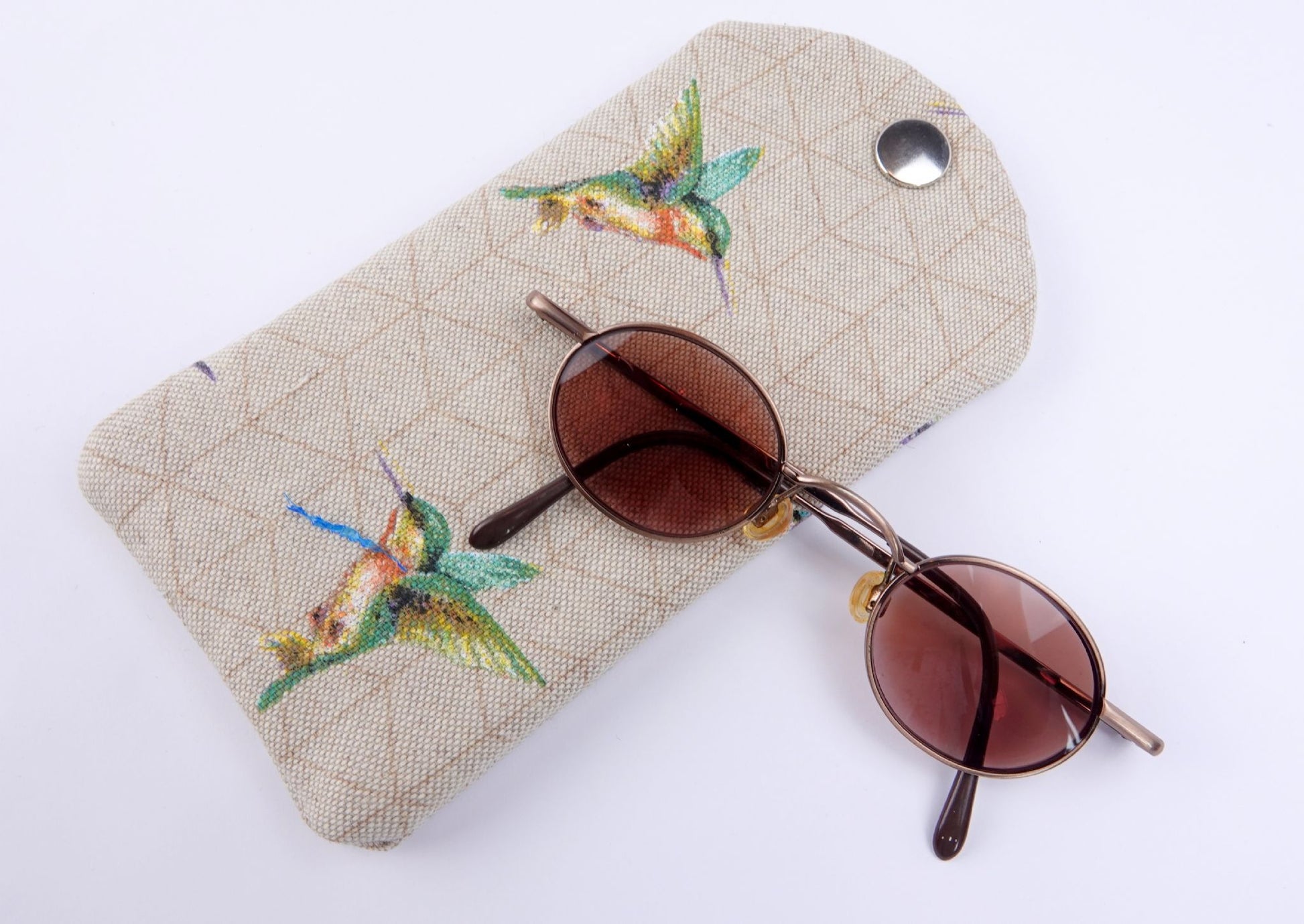 humming bird glasses case pictured with a pair of sunglasses